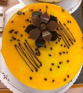 Keltainen kakku, jonka päällä on suklainen koriste